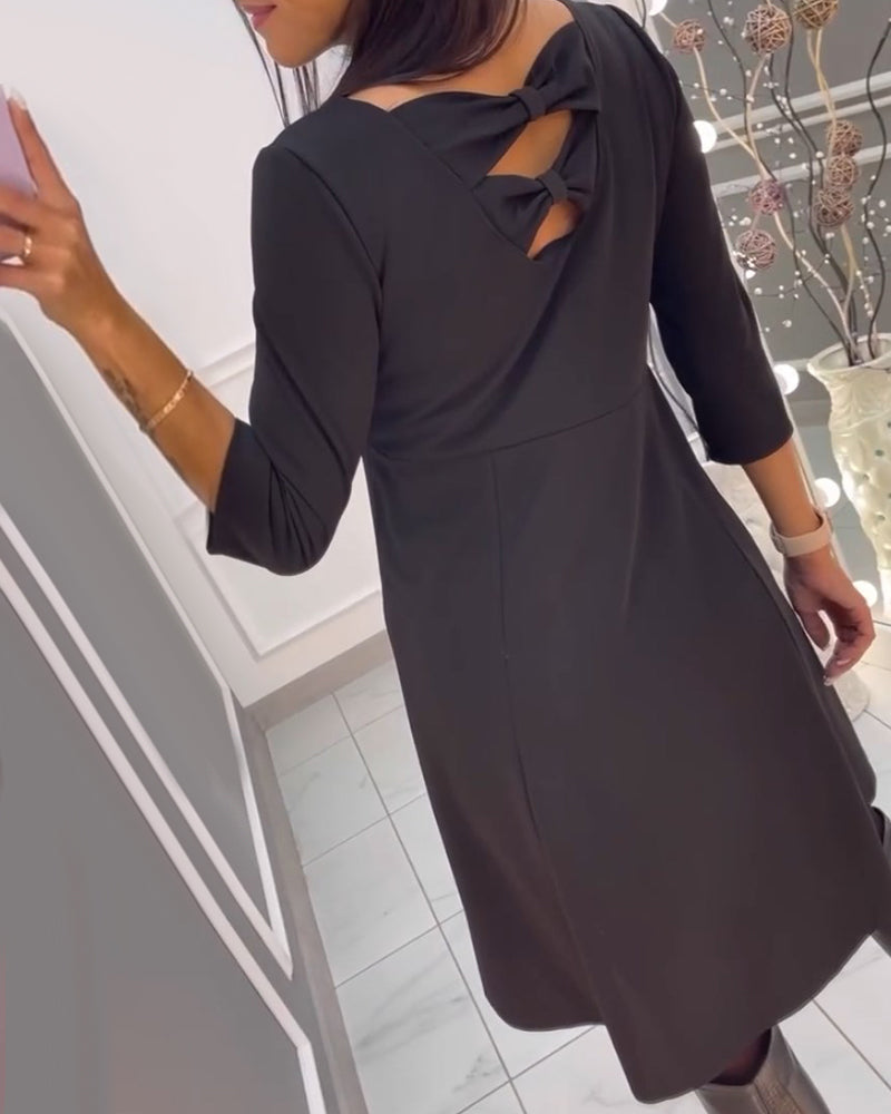 Enfärgad klänning med rosett rygg