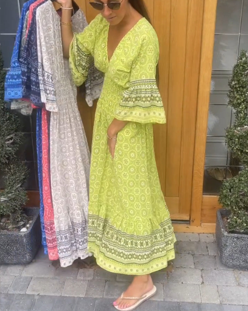 Lång klänning med djup V-ringning och utsvängd ärm