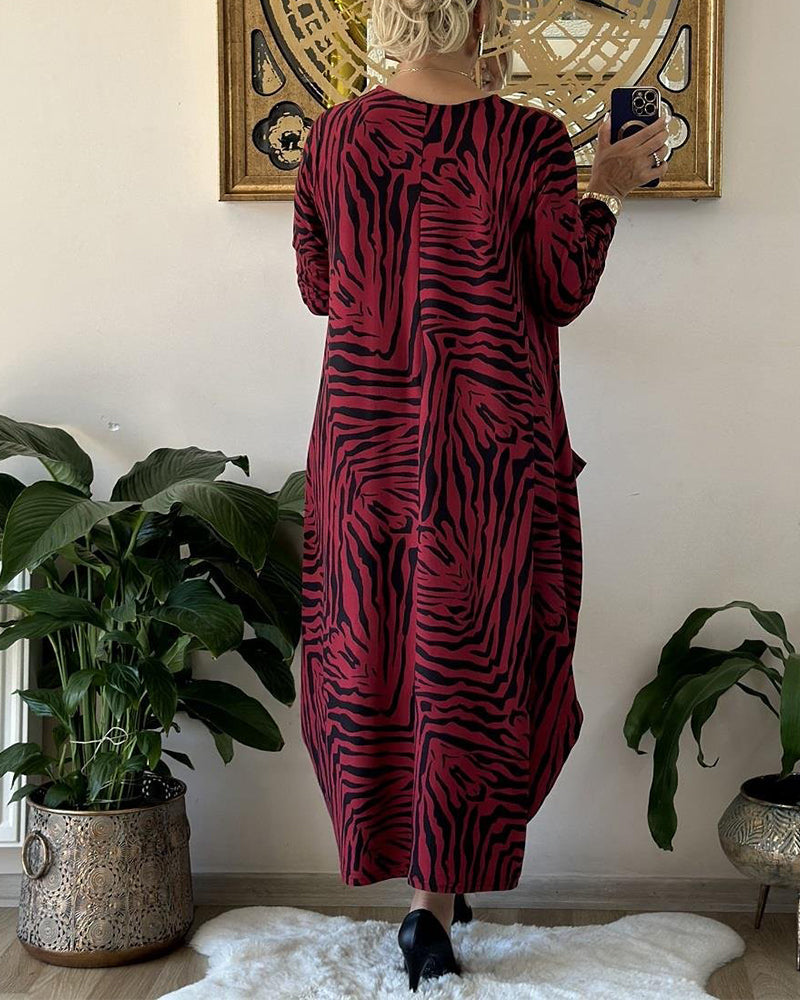 Lös modeklänning med tryck och fickor