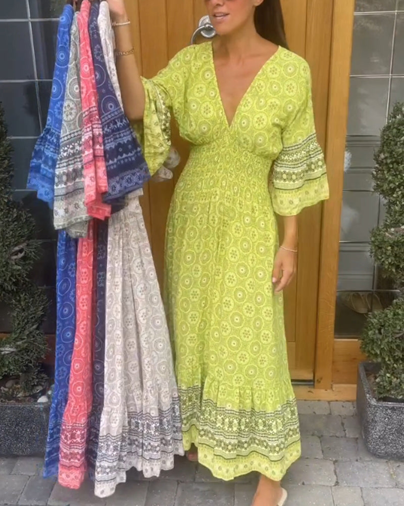 Lång klänning med djup V-ringning och utsvängd ärm