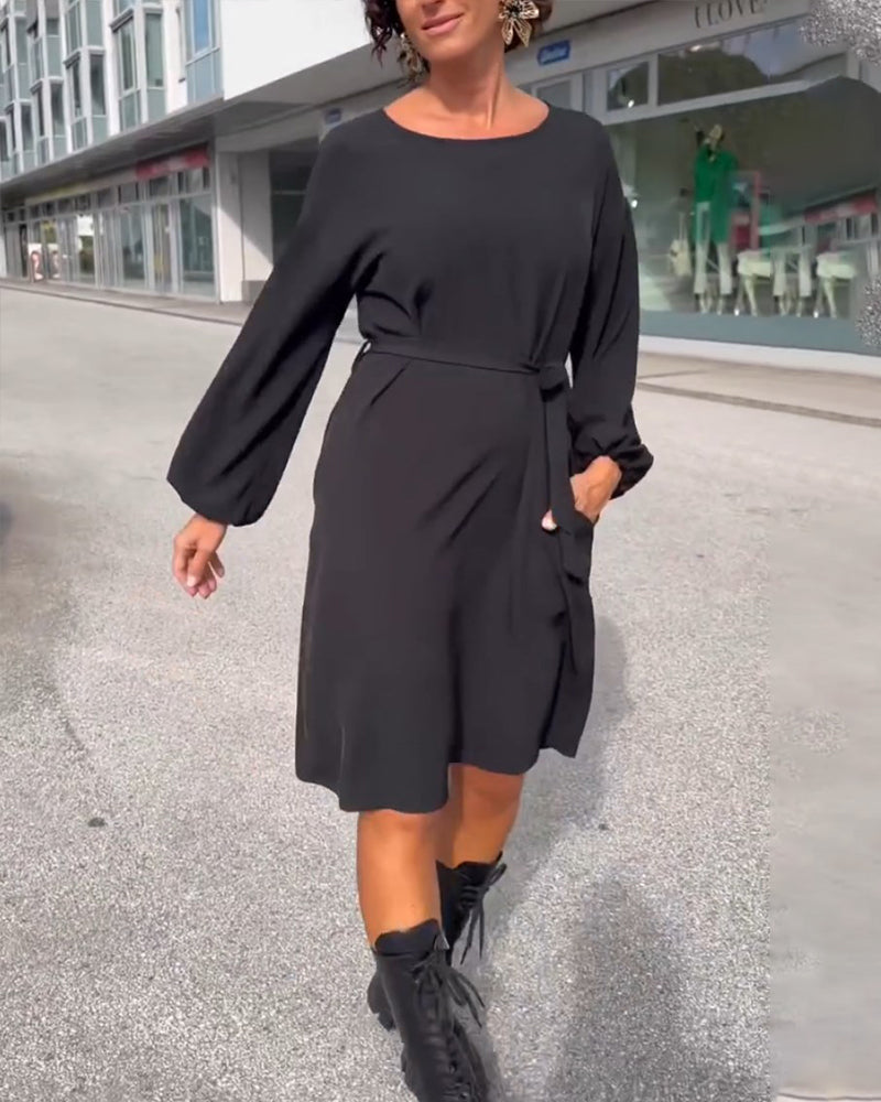 Enfärgad klänning med rund hals och knytband